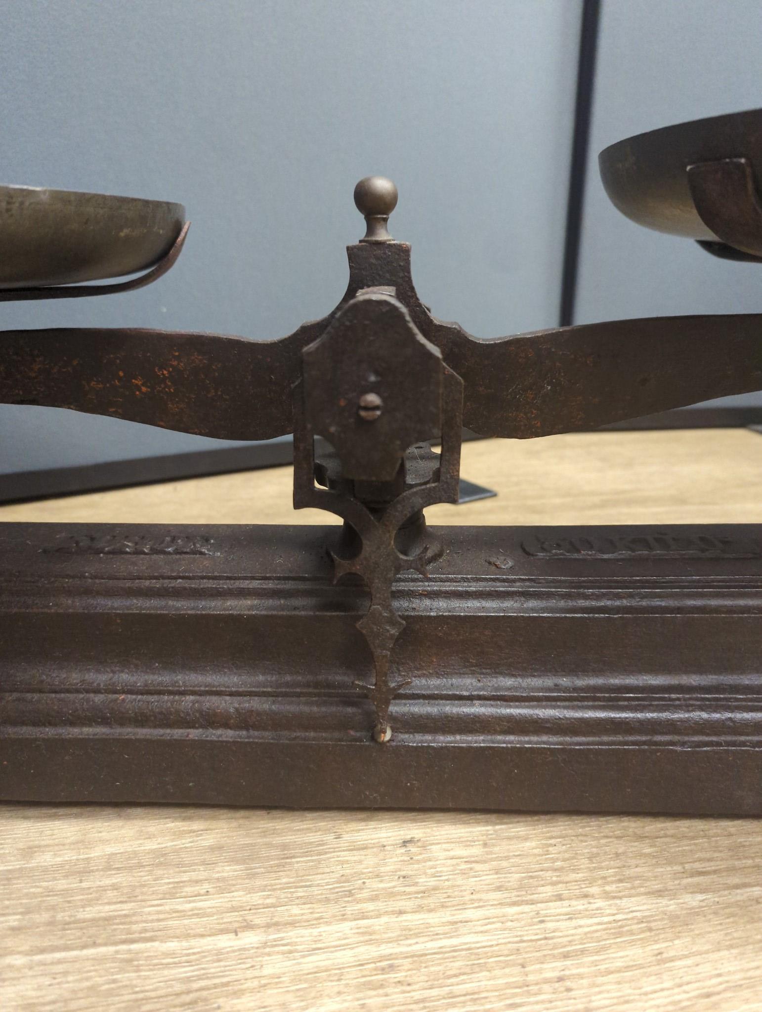 A large French cast iron and brass weighing scale, 82 cms wide.